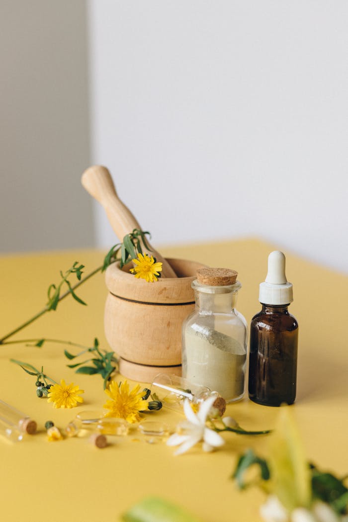 Aromatic herbs with mortar, pestle, and bottles for natural medicine concept.